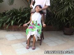 Asian teen tied up and hand cuffed on a chair
